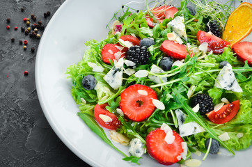 Salad. Salad of arugula, blue cheese, strawberries and blueberries. Top view.