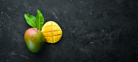 Fresh mango on a black background. Top view. Free space for your text.