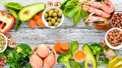 Healthy diet food: spinach, parsley, shrimp, pumpkin seeds, eggs, avocados, broccoli. Top view.