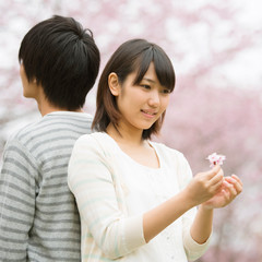 桜の前で背中合わせに立つカップル