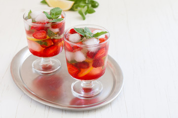 
Summer cold drink . Lemonade with mint and strawberries on a light background.