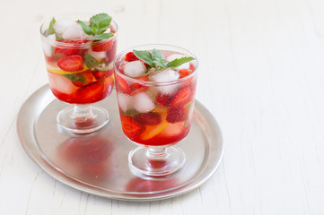 
Summer cold drink . Lemonade with mint and strawberries on a light background.