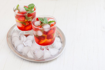 
Summer cold drink . Lemonade with mint and strawberries on a light background.