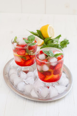 
Summer cold drink . Lemonade with mint and strawberries on a light background.