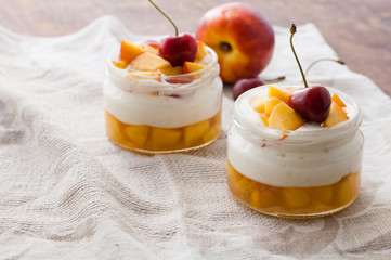 Summer dessert of peaches and yoghurt with a sweet cherry, selective focus
