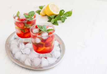 
Summer cold drink . Lemonade with mint and strawberries on a light background.