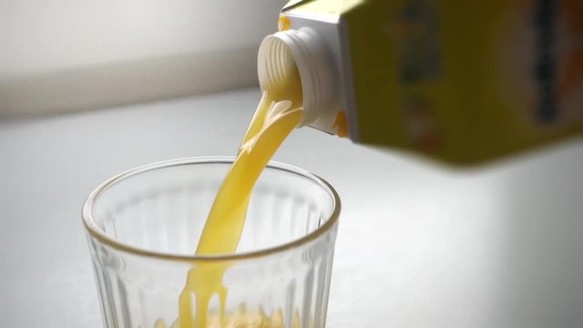 pouring orange juice in a glass