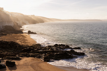 Obraz premium Morning mist on the cliffs along Porthleven Sands in Cornwall, England, UK.
