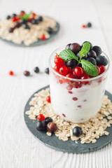 Healthy homemade greek yogurt with ribes, blueberries, oatmeal and mint