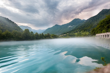 Fototapeta na wymiar Foggy lake with moving water in Triglav national park in the Julian Alps, Slovenia