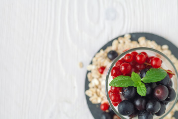 Healthy homemade greek yogurt with ribes, blueberries, oatmeal and mint