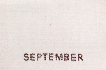 The word September written with coffee beans shot from above, aligned at the bottom.