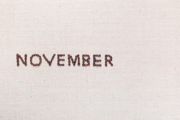 The word November written with coffee beans shot from above, aligned to the left.