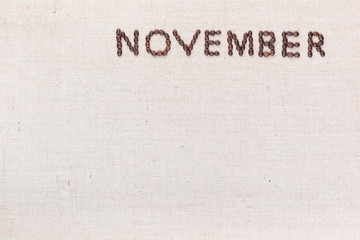 The word November written with coffee beans shot from above, aligned at the top right.