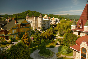 Fototapeta na wymiar view from a height. modern luxury hotel in Victorian style with beautiful well-groomed trees against the backdrop of a mountain range and blue sky in clear sunny weather