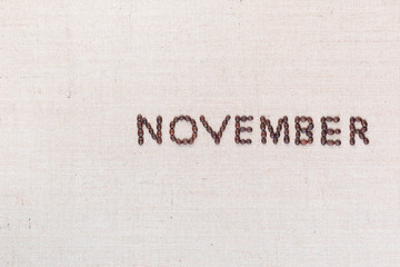 The word November written with coffee beans shot from above, aligned to the right.