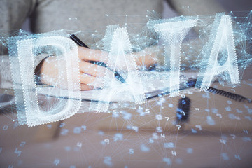 Double exposure of writing hand on background with data technology hologram. Big data concept.