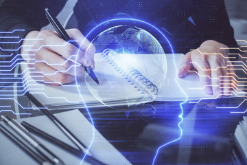 Double exposure of writing hand on background with brain hologram. Concept of learning.
