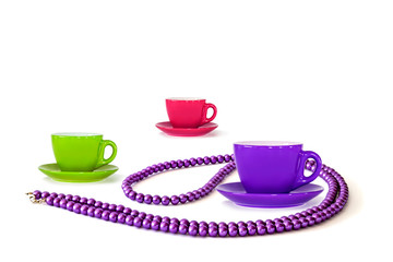 purple pearl beads on white background isolate. mug with saucer multicolored set colors 