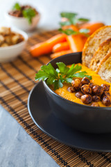 Fresh vegan plate of carrots cream soup with chickpeas