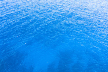 Blue sea water with small waves and color gradient texture background.