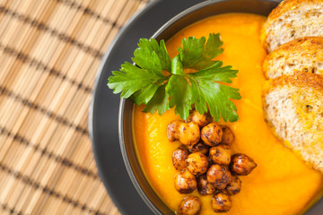 Fresh vegan plate of carrots cream soup with chickpeas