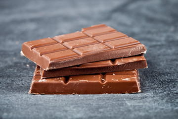 Milk chocolate bar pieces closeup. Sweet food photo concept.