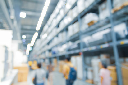 Blurred bix box store supercenter with customers shopping for home goods.