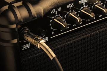 Guitar amplifier with jack plugged in. Close up macro view - obrazy, fototapety, plakaty