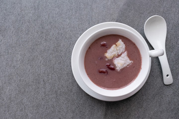 Grill mochi with boiled red beans in white bowl on table.