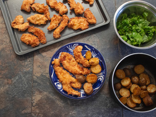 Traditional Fried Chicken Strips Plate with Potatoes and fresh Green Salad 