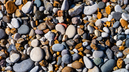 Close up detail shot of various sized stones and pebbles taken at the beach (Seaham) on a sunny day.