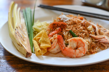 Pad thai , Thai style noodle with shrimps on white dish and wooden table