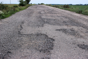 Unsafe, destroyed rural road, in disrepair.