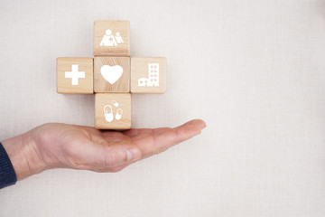 Doctor hand holds wood block stacking with icon healthcare medical, insurance for your health concept.