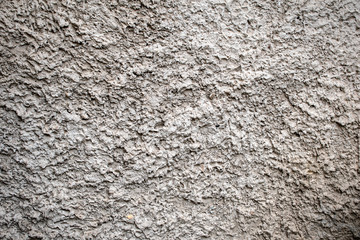 The texture of the gray stony surface covered with cement