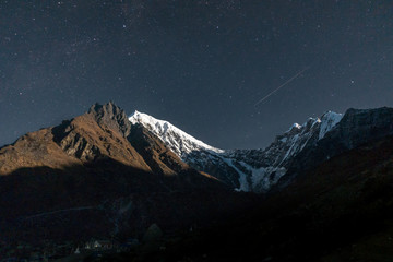 Himalayas peaks and glacier during night with stars and startrail