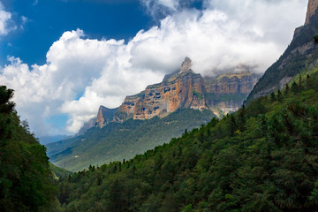 Monte Perdido rocky valley with scenic clouds and cliffs in background
