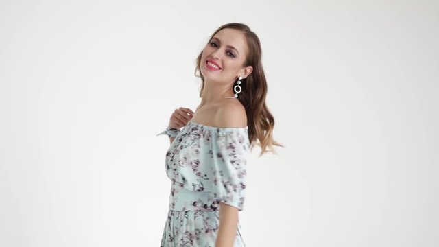 Cute girl in a dress with a flower coloring, smiling on a white background. The style of 60-ies. Fashionable clothes in the style of 60-ies