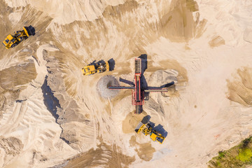 Aerial view of bulldozer pouring sand into truck