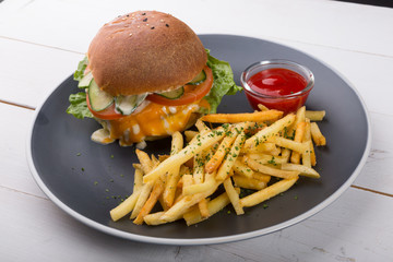 Burger served with french fries and ketchup