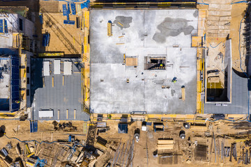 Construction crane next to the house under construction from a height, aerial view