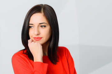 Fototapeta na wymiar brunette thoughtful smily young woman wearing red