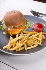Burger served with french fries and ketchup