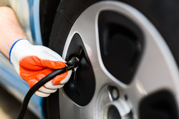 driver checking air pressure in the tires close up