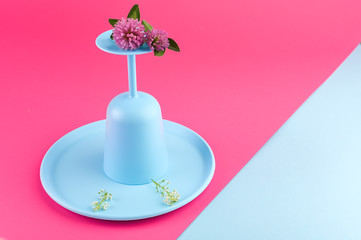 Plastic dishes bright colors for a picnic. Pink background and blue crockery. Copy space,