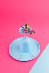 Plastic dishes bright colors for a picnic. Pink background and blue crockery. Copy space,