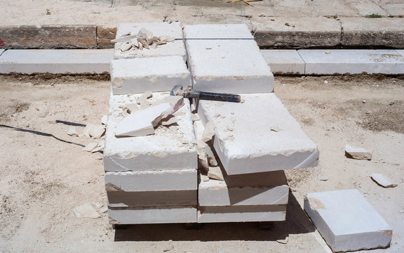 Closeup of a large piece of marble and a hammer after splitting marble for further work.