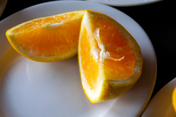 Portion of organic orange, vitamin C, on porcelain plate, tropical breakfast in Guatemala, Central America.