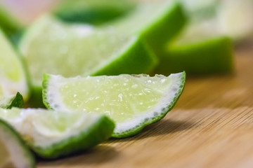 lime slices on wooden table, close up blurry background